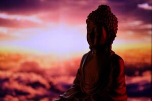 Buddha Purnima and Vesak day concept, Buddha statue with low key light against beautiful and colorful background. Meditation photo