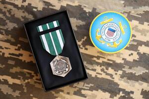 KYIV, UKRAINE - JULY 10, 2024 The Coast Guard Commendation medal. United States military award medal with ribbon and pin. Handmade paper theater props photo