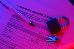 Filling up pre tenancy application form. Tenancy agreement for rental lease and keys photo
