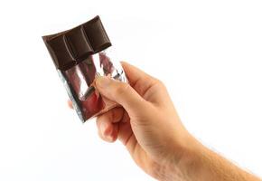 Hand holds a bar of chocolate isolate close-up photo