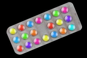 Multicolored vitamin pills in a transparent blister photo