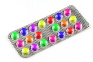 Multicolored vitamin pills in a transparent blister photo