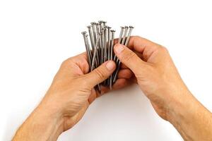 Hands holding nails. Construction nails in hand isolate. photo