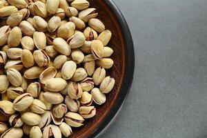 Pistachio nuts in a plate. Place for text photo