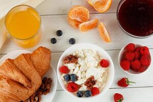 Breakfast with cheese and croissant. breakfast table with cheese, berries and croissant. Top view of breakfast photo