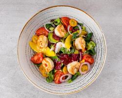 Salad with shrimps in sweet and sour sauce with mango and avocado. on a gray background photo