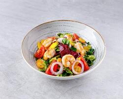 Salad with shrimps in sweet and sour sauce with mango and avocado. on a gray background photo