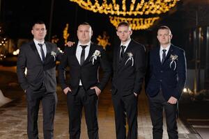 Four men in suits and ties pose for a photo. Scene is formal and elegant photo