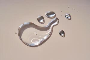 A drop of micellar water on a beige background. photo