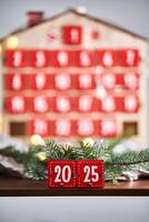 Christmas Advent calendar in the shape of a house with boxes making up the number 2025. photo
