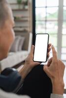 Senior Woman Using Smartphone at Home with Blank Screen for Mockup or App Presentation photo