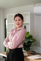 Confident Businesswoman Standing in Modern Office with Arms Crossed and Smiling photo