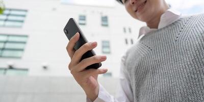 Business Professional Using Smartphone Outside Modern Office Building for Communication and Networking photo