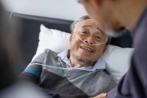 Senior fatal dying male patient with oxygen mask is getting consoling support from his friend and family while suffering from final stage cancer at home with palliative medical treatment concept photo