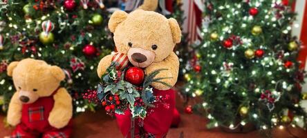 christmas tree decorated with balls and lights and christmas presents, teddy bear in christmas color, with little red bow photo