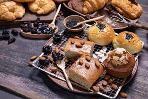 Table top view of organic rustic style bakery with whole grain bun, bread and cookies with various berry and nut for homemade healthy pastry and traditional baking bread photo