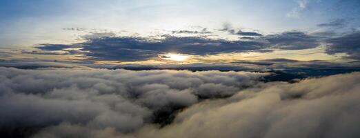 Panorama shot of colorful light of sunrise over rainforest mountains with fog and cloud inversion for natural cinematic of national park and wildlife reserve area photo