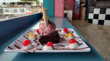 a dessert on a plate with ice cream and fruit photo