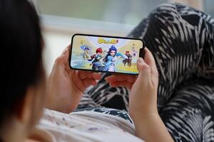 Fantasy Westward Journey mobile iOS game on iPhone 15 smartphone screen in female hands during mobile gameplay photo
