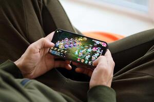 Fantasy Westward Journey mobile iOS game on iPhone 15 smartphone screen in male hands during mobile gameplay photo