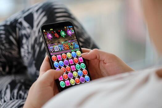 Puzzle and dragons mobile iOS game on iPhone 15 smartphone screen in female hands during mobile gameplay photo