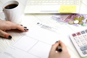 KYIV, UKRAINE - OCTOBER 31, 2023 Accountant fill french tax form Notice of housing tax in end of tax period. Taxation and paperwork routine photo