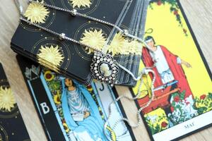 KYIV, UKRAINE - JULY 10, 2024 Tarot minor and major arcana cards of Rider Waite esoteric deck and vintage brooch with female silhouette. Many tarot cards for fortune telling and old amulet photo