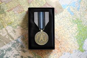KYIV, UKRAINE - JULY 10, 2024 US Space Force Good Conduct medal. United States military award medal with ribbon and pin. Handmade paper theater props photo