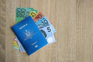 KYIV, UKRAINE - JULY 10, 2024 Australian blue travel passport and money on wooden background photo