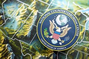 KYIV, UKRAINE - JUNE 26, 2024 United States National Counterterrorism Center coat of arms on paper map of United States photo