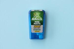 KYIV, UKRAINE - APRIL 20, 2024 Halls mini mints mint twist energy vitamin b6 small blue case with hard mints inside on blue background photo