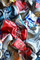 KYIV, UKRAINE - APRIL 20, 2024 Background of various crashed beer cans. Recycle aluminum metal crushed tin can waste photo