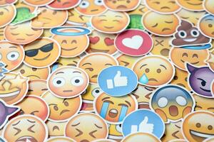 KYIV, UKRAINE - APRIL 20, 2024 Large set of stickers with Emoji yellow faces. Emoji is a pictogram or smiley embedded in text and used in electronic messages photo