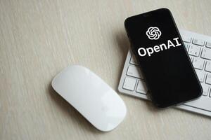 KYIV, UKRAINE - MARCH 17, 2024 OpenAI logo on iPhone display screen with apple keyboard and mouse on table photo