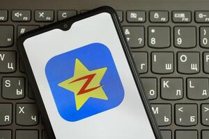 KYIV, UKRAINE - APRIL 1, 2024 Qzone icon on smartphone screen on black keyboard photo