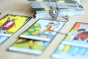 KYIV, UKRAINE - JULY 10, 2024 Tarot minor and major arcana cards of Rider Waite esoteric deck and vintage brooch with female silhouette. Many tarot cards for fortune telling and old amulet photo