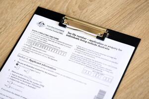 KYIV, UKRAINE - JULY 10, 2024 Australian Tax File Number Application or enquiry for individuals living outside Australia blank form lies on table of Australian Government taxation office photo