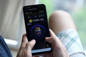 KYIV, UKRAINE - APRIL 20, 2024 Hamster Kombat telegram bot on smartphone screen. Hamster Kombat is a viral Telegram crypto game for earn HMSTR tokens by managing virtual crypto exchange photo