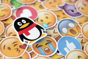 KYIV, UKRAINE - APRIL 20, 2024 Tencent QQ Weibo logo and large set of stickers with Emoji yellow faces. Emoji is a pictogram or smiley embedded in text and used in electronic messages photo