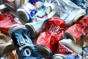 KYIV, UKRAINE - APRIL 20, 2024 Background of various crashed beer cans. Recycle aluminum metal crushed tin can waste photo