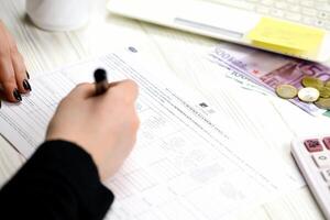 KYIV, UKRAINE - OCTOBER 31, 2023 Accountant fill french tax form 2041E Withholding tax declaration in end of tax period. Taxation and paperwork routine photo