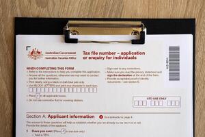 KYIV, UKRAINE - JULY 10, 2024 Australian Tax File Number Application or enquiry for individuals blank form lies on table of Australian Government taxation office photo