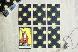 KYIV, UKRAINE - JULY 10, 2024 Tarot minor and major arcana cards of Rider Waite esoteric deck and vintage brooch with female silhouette. Many tarot cards for fortune telling and old amulet photo