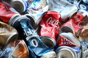 KYIV, UKRAINE - APRIL 20, 2024 Background of various crashed beer cans. Recycle aluminum metal crushed tin can waste photo