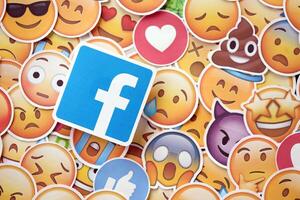 KYIV, UKRAINE - APRIL 20, 2024 Facebook logo and large set of stickers with Emoji yellow faces. Emoji is a pictogram or smiley embedded in text and used in electronic messages photo