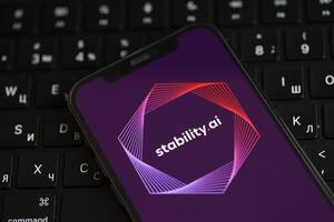 KYIV, UKRAINE - MARCH 17, 2024 StabilityAI logo on iPhone display screen and MacBook keyboard photo