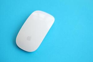 KYIV, UKRAINE - NOVEMBER 27, 2023 Apple Magic Mouse 3rd generation lies on bright colored background photo
