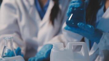 Close-up of a scientist's hands holding a flask with pink liquid in a lab. video