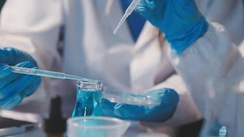 Close-up of a scientist's hands holding a flask with pink liquid in a lab. video