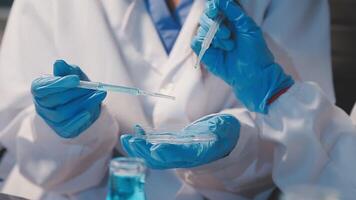Close-up of a scientist's hands holding a flask with pink liquid in a lab. video